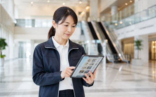 清掃会社のエリアマネージャーがタブレットで品質レポートを確認している様子